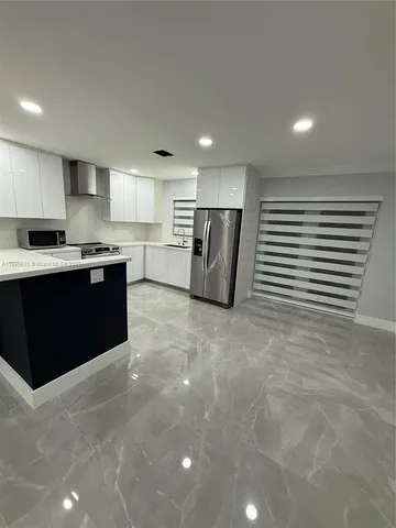 a kitchen with stainless steel appliances granite countertop a refrigerator sink and cabinets