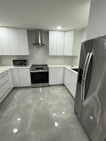a kitchen with a refrigerator and a stove top oven