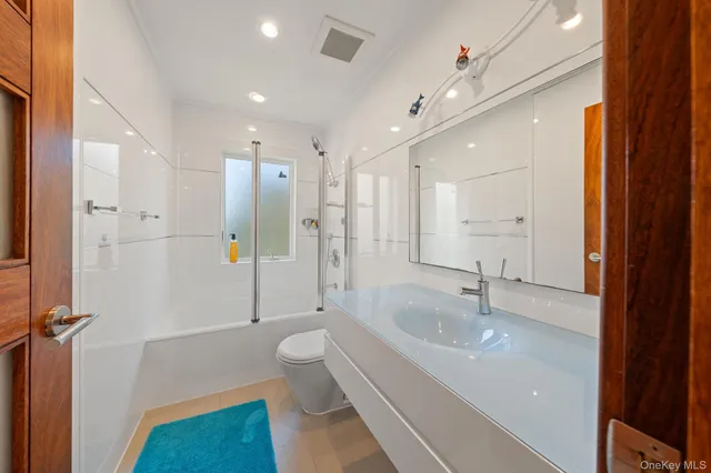 a spacious bathroom with a granite countertop sink toilet and shower