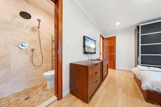 a living room with furniture a flat screen tv and a refrigerator