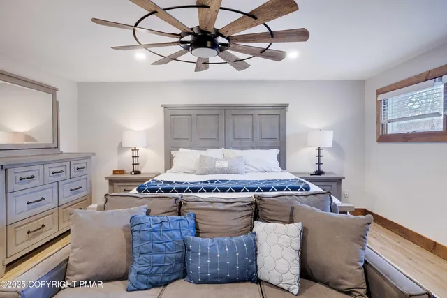 a bedroom with a bed a window and a flat screen television