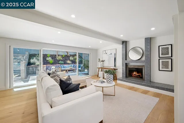a living room with furniture a fireplace and a large window
