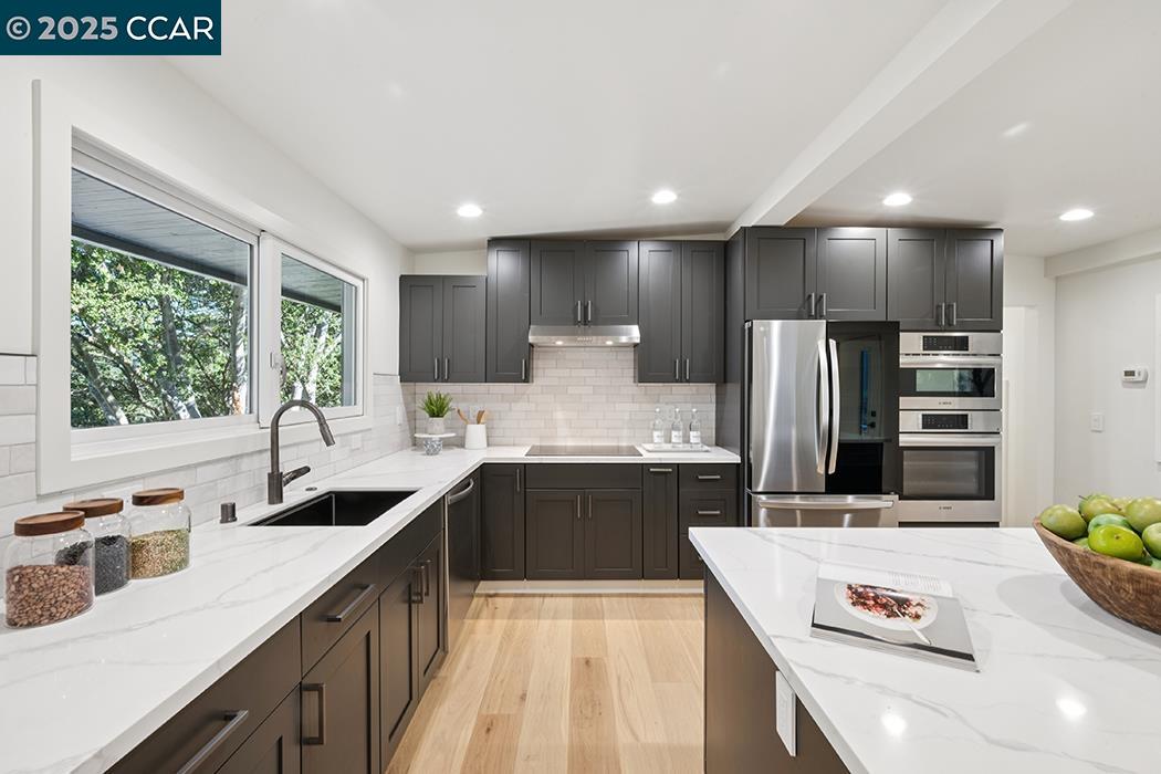 26 Berkeley Avenue Orinda, CA 94563 - Photo 8 of 28 a large kitchen with stainless steel appliances granite countertop a sink dishwasher a refrigerator and a stove with wooden floor