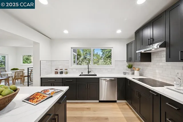 a kitchen with stainless steel appliances granite countertop a sink a stove and refrigerator