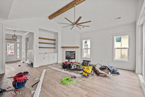 498 Genoe's Point Road Southwest Supply, NC 28462 - Photo 27 of 34 Large Open living Room with corner Herringbone tiled Fireplace with wood mantle and center beam and built ins