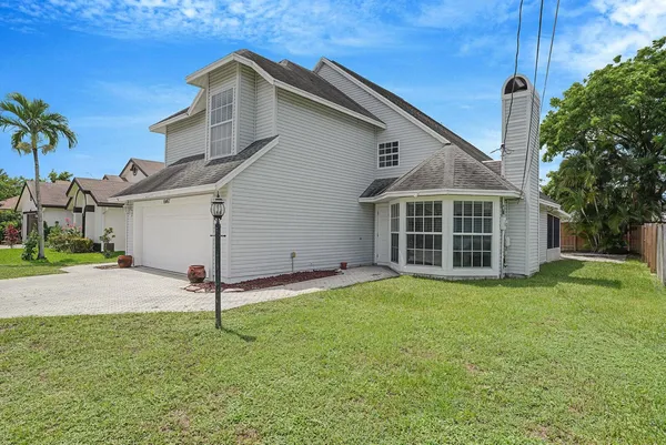 a view of a house with a yard and garage