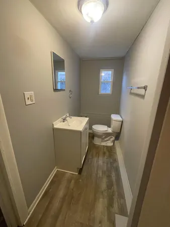 a bathroom with a sink toilet and chair