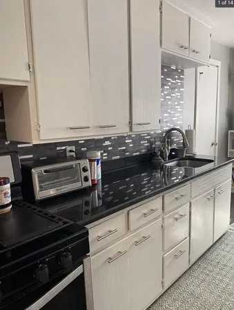 a kitchen with granite countertop a stove and a sink