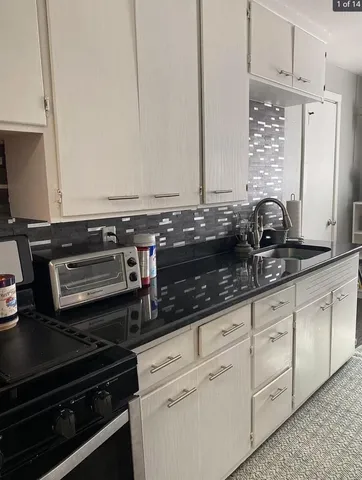 a kitchen with granite countertop a stove and a sink