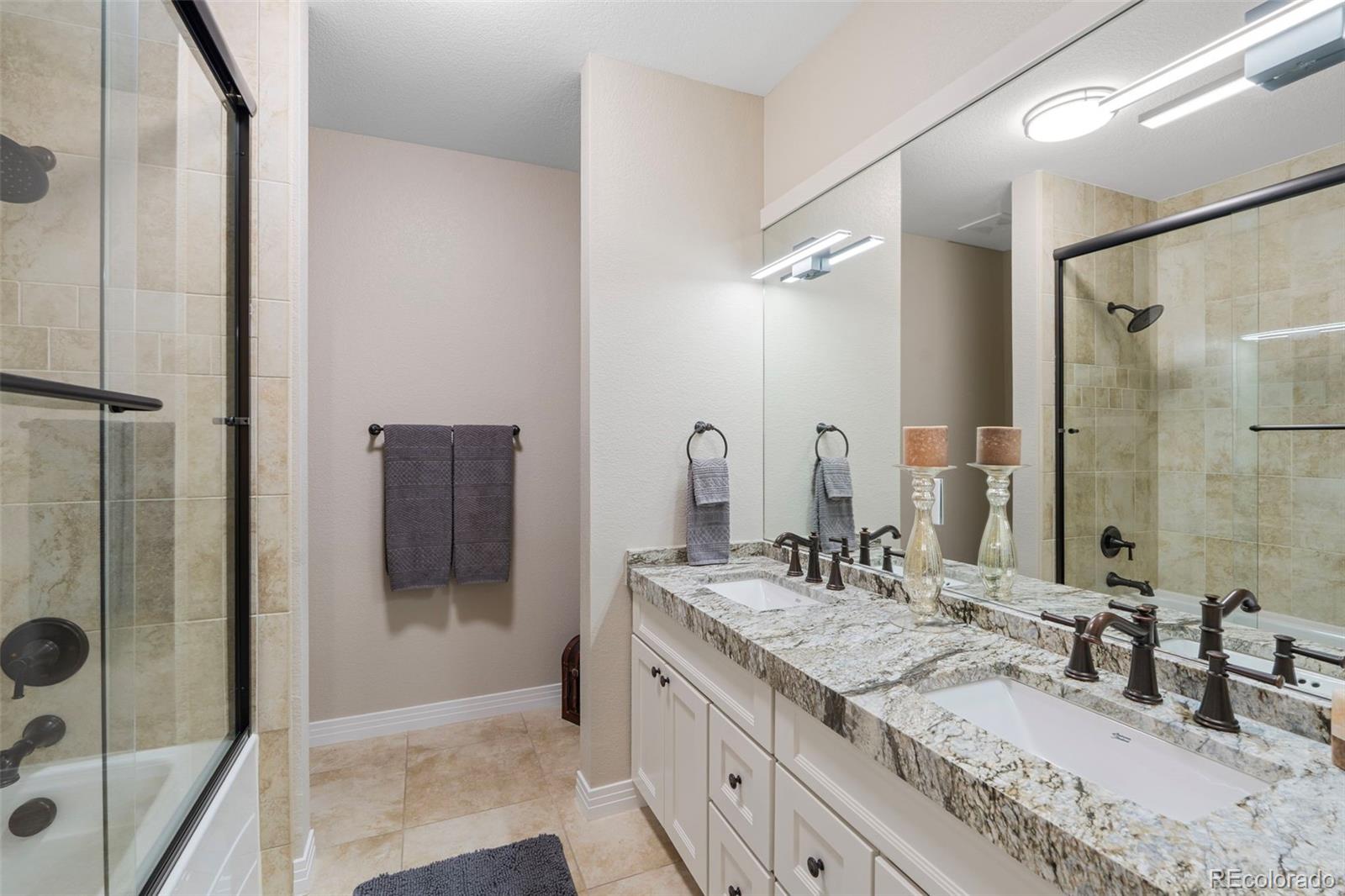 730 Genesee Mountain Road Golden, CO 80401 - Photo 39 of 50 a bathroom with a granite countertop sink mirror and shower