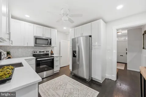 a kitchen with stainless steel appliances granite countertop a refrigerator stove and sink