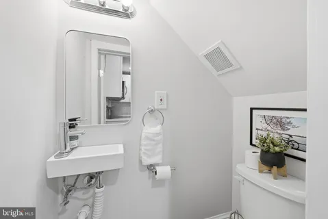 a bathroom with a sink a toilet and mirror