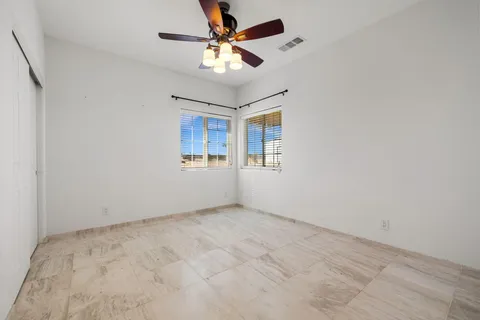 a backyard of a house with sofas table and chairs