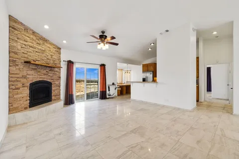 a view of a livingroom with a fireplace a sink and dishwasher next to a window