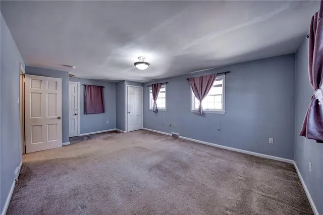 an empty room with windows and closet