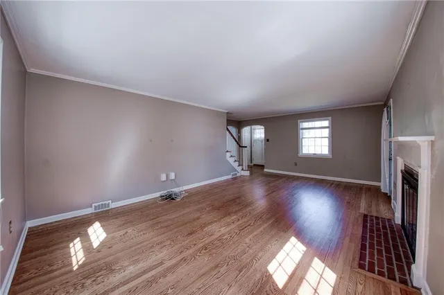 a view of empty room with window and wooden floor