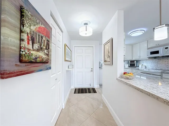 a hallway with painting on the wall and a granite top
