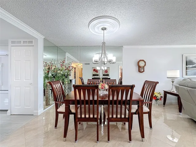 a view of a dining room with furniture and chandelier