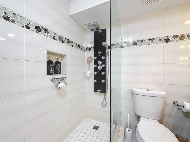 a bathroom with a toilet and a shower
