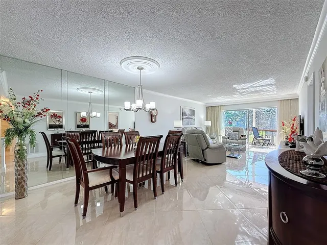a dining room with furniture a chandelier and window