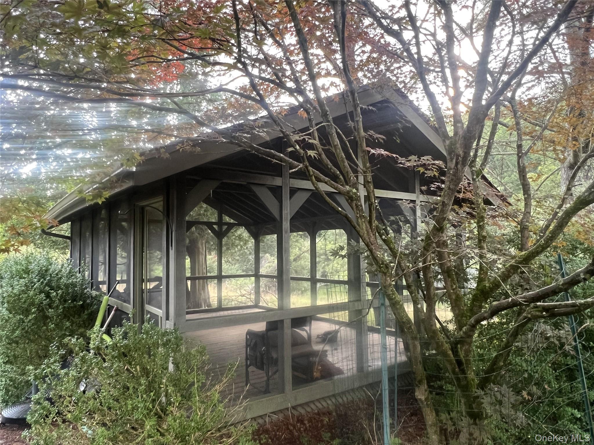 259 Lackawaxen Road Narrowsburg, NY 12764 - Photo 15 of 34 a backyard of a house with table and chairs under an umbrella