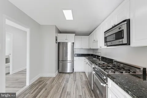 a kitchen with granite countertop a stove and a refrigerator