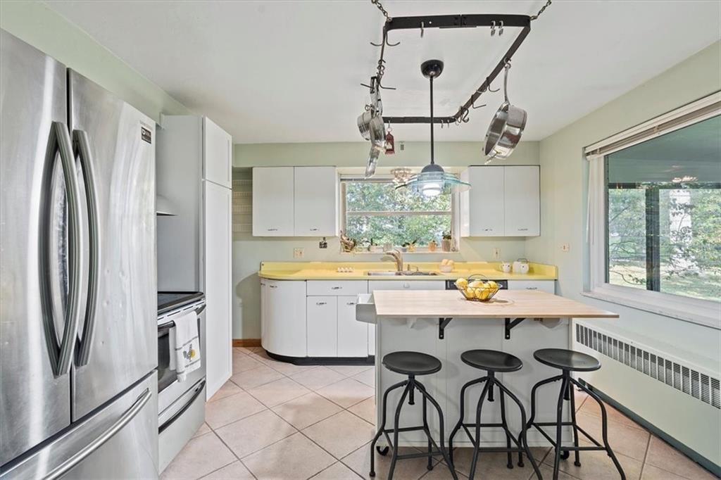393 Brewer Road Rochester, PA 15074 - Photo 8 of 25 a kitchen with stainless steel appliances a dining table chairs and chandelier