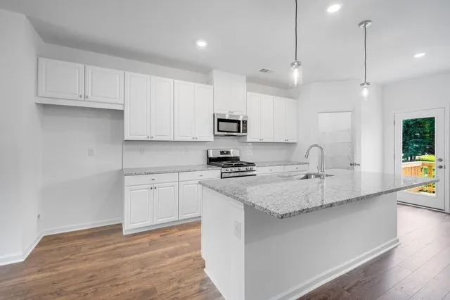 a view of kitchen with wooden floor and a ceiling fan