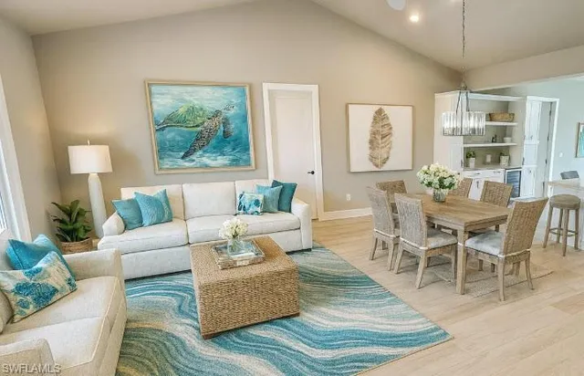 a living room with stainless steel appliances furniture and a view of kitchen