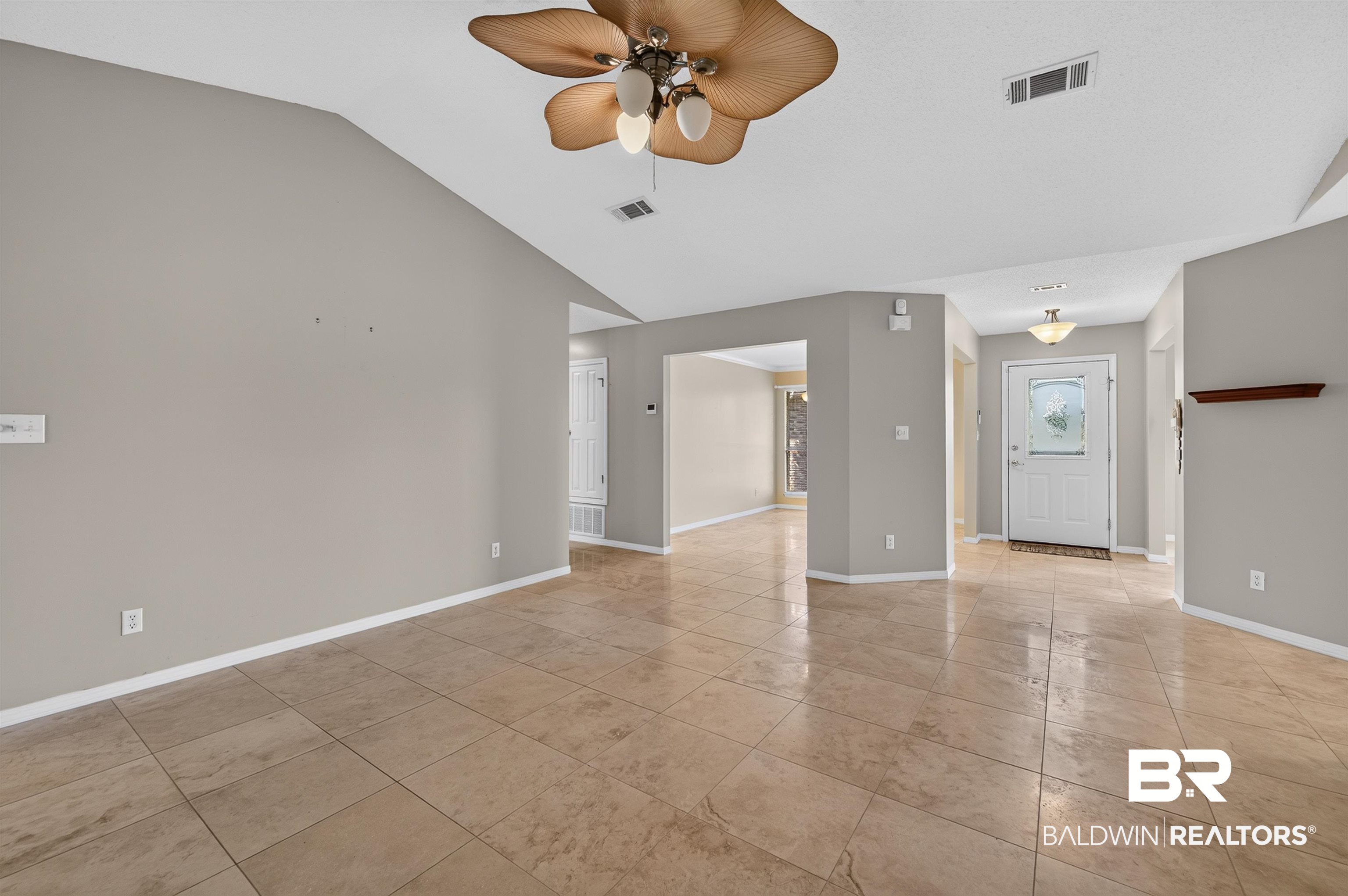 22685 County Road 12 Foley, AL 36535 - Photo 36 of 89 Open-concept living space featuring vaulted ceilings, neutral-toned walls, and large format tile flooring