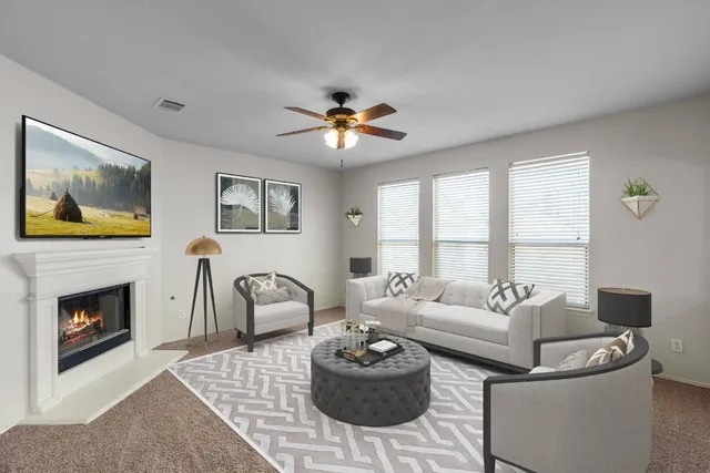 a living room with furniture a fireplace and a flat screen tv