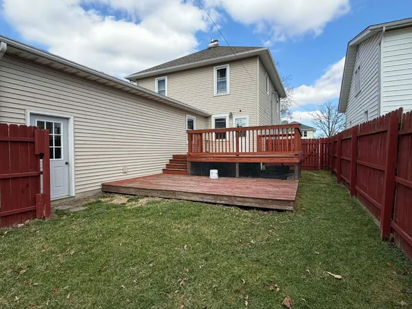 a view of a house with a yard and deck
