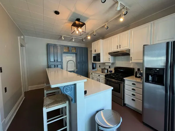 a kitchen with stainless steel appliances a sink stove and cabinets