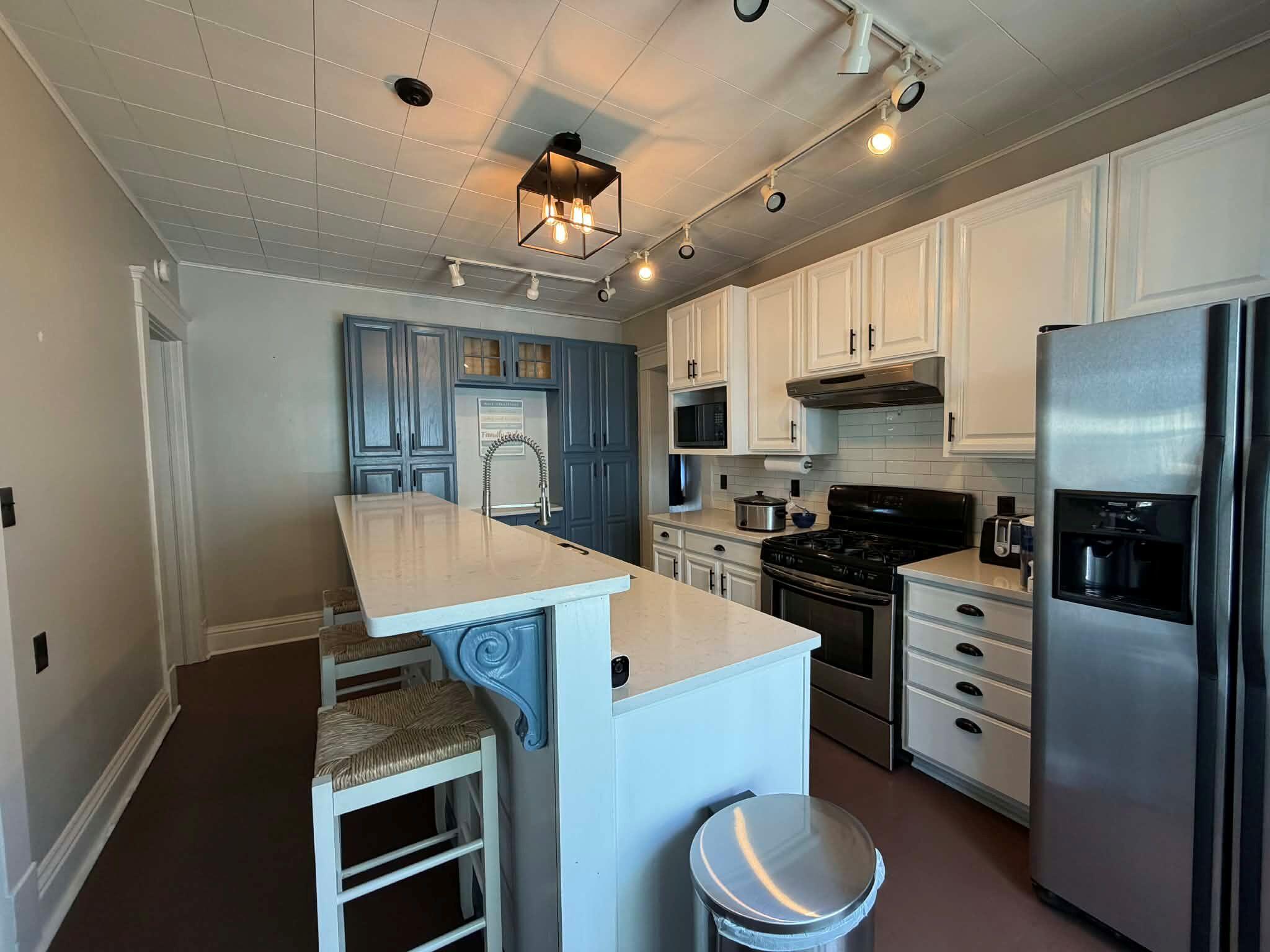 320 South Cullen Street Rensselaer, IN 47978 - Photo 10 of 23 a kitchen with stainless steel appliances a dining table chairs stove refrigerator and cabinets
