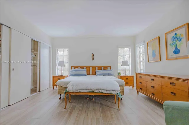 a view of a livingroom with furniture wooden floor kitchen view and a chandelier