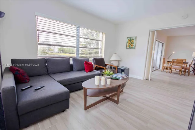a living room with furniture and a floor to ceiling window