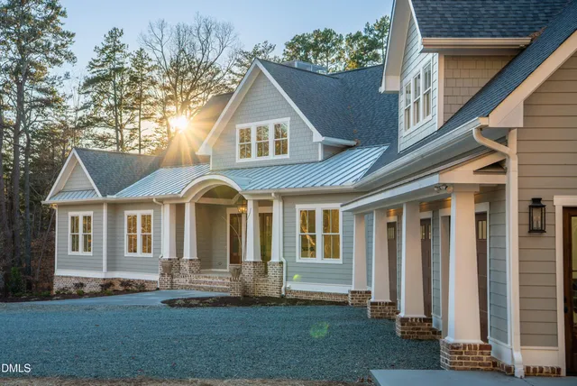 a front view of a house with a tree
