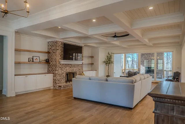a living room with furniture and a large window with wooden floor