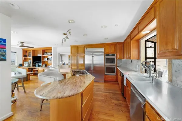 a kitchen with stainless steel appliances granite countertop a stove a sink dishwasher and cabinets with wooden floor