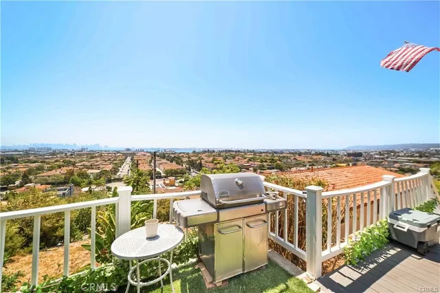 a view of a roof deck with couches under an umbrella