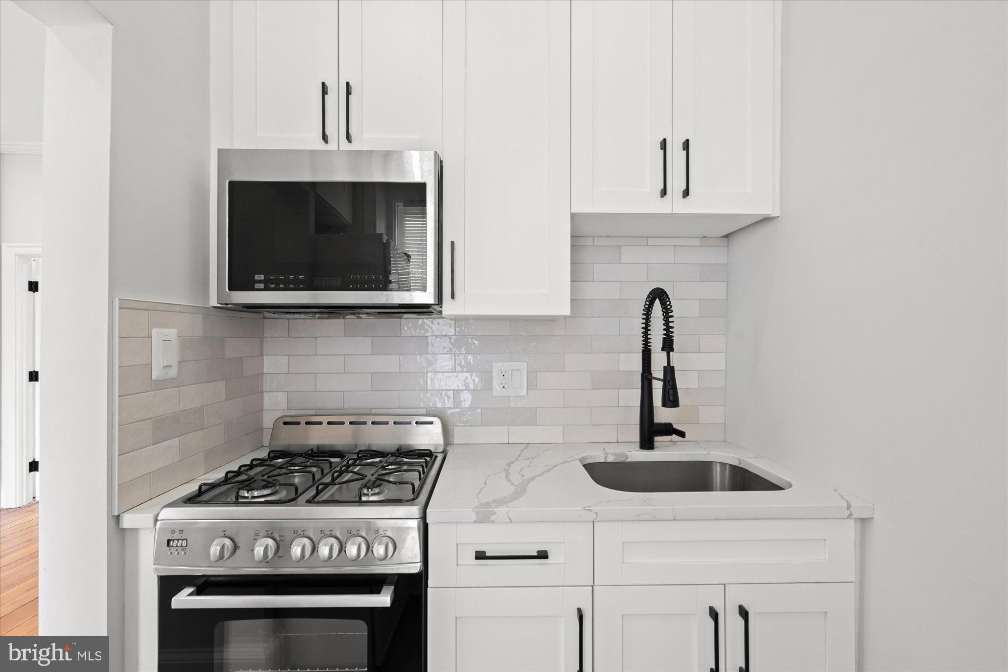 524 Queen Street Alexandria, VA 22314 - Photo 29 of 64 a kitchen with appliances a sink and cabinets