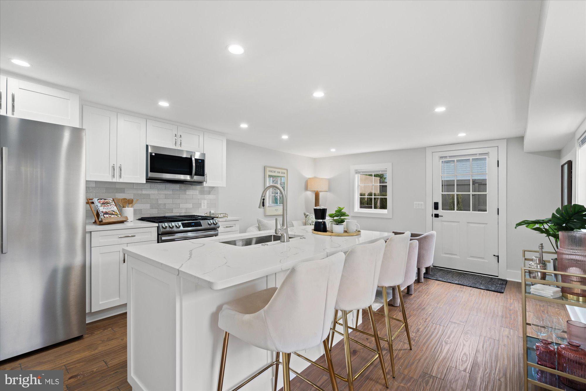 524 Queen Street Alexandria, VA 22314 - Photo 42 of 64 a kitchen with stainless steel appliances a dining table chairs refrigerator and microwave