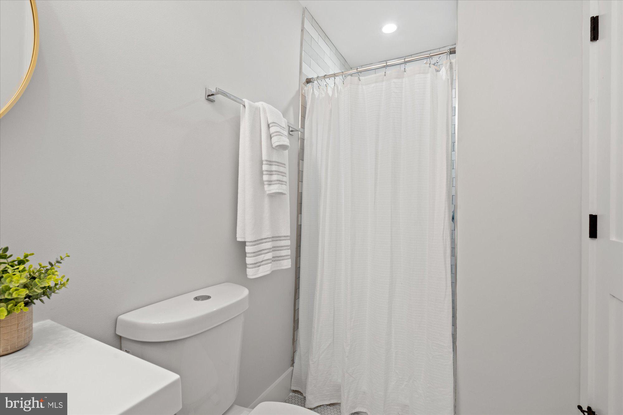 524 Queen Street Alexandria, VA 22314 - Photo 50 of 64 a bathroom with a shower curtain and a toilet