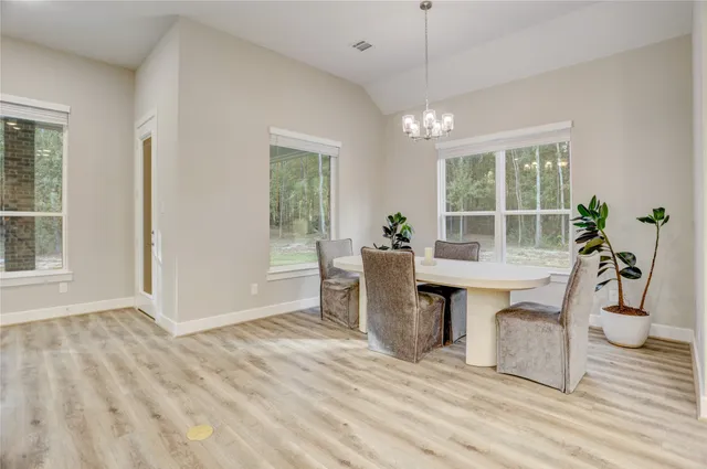 a dining room with wooden floor and a chandelier