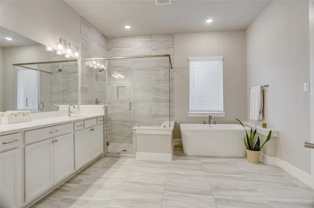 a large bathroom with a double vanity sink a large mirror and a bathtub