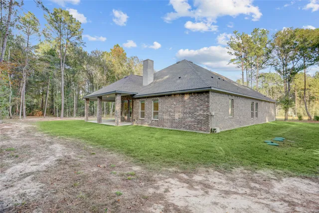 a view of an house with backyard space and balcony