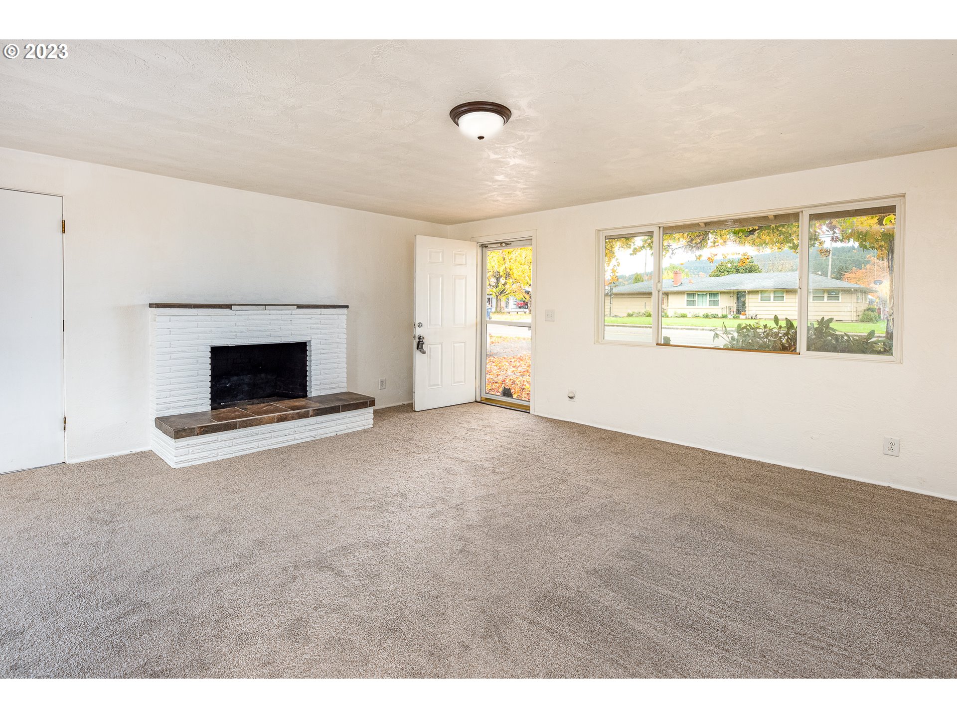3944 Jasper Road Springfield, OR 97478 - Photo 4 of 25 a view of an empty room with a window and a fireplace