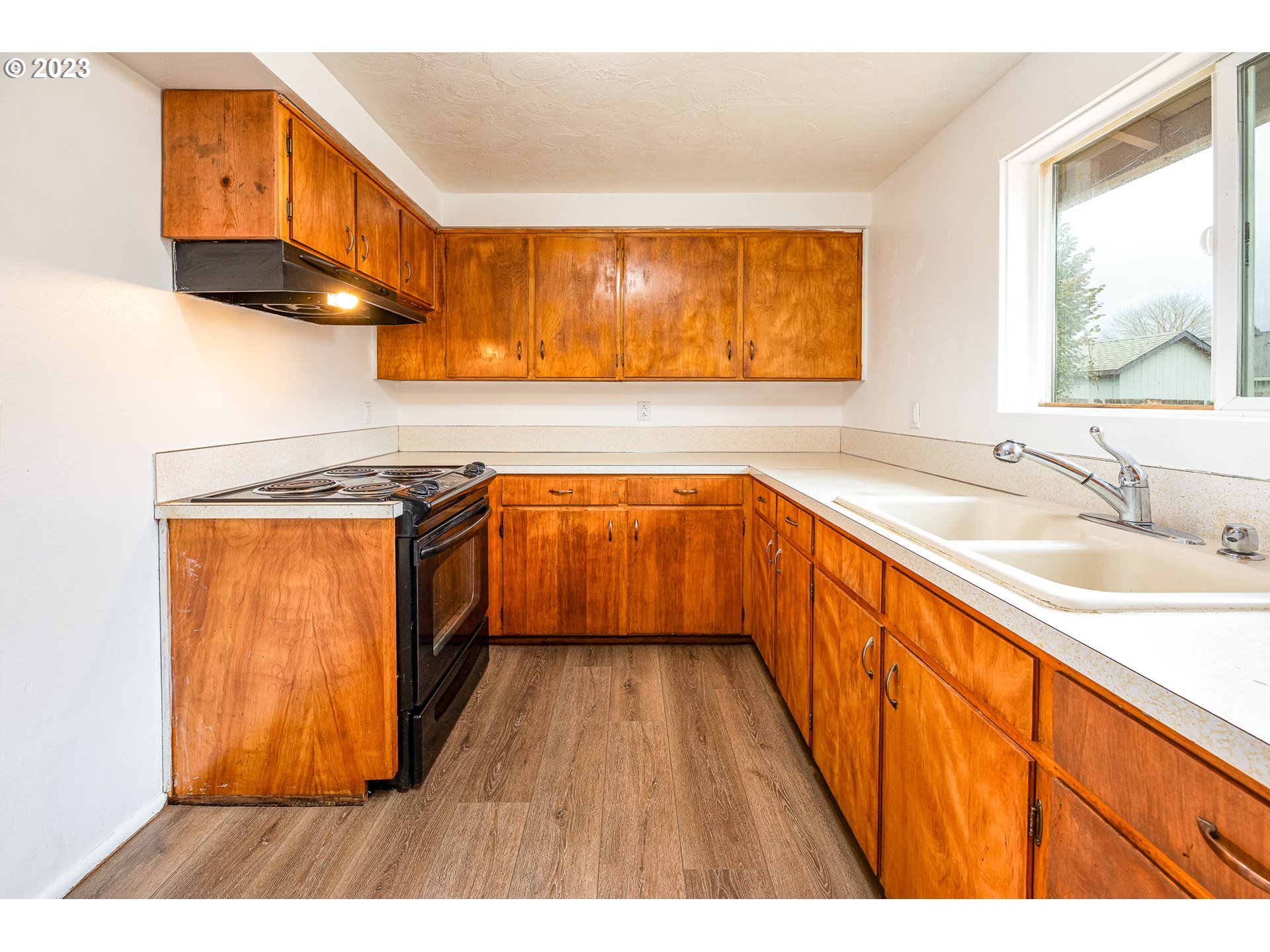3944 Jasper Road Springfield, OR 97478 - Photo 8 of 25 a kitchen with stainless steel appliances granite countertop a sink a stove and a wooden floors