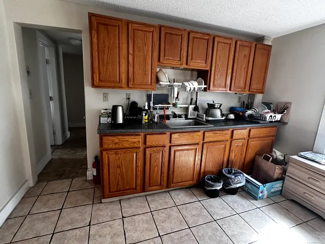 a kitchen with granite countertop a stove a sink and cabinets