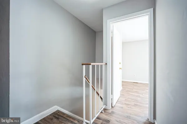 a view of a hallway with wooden floor and entryway